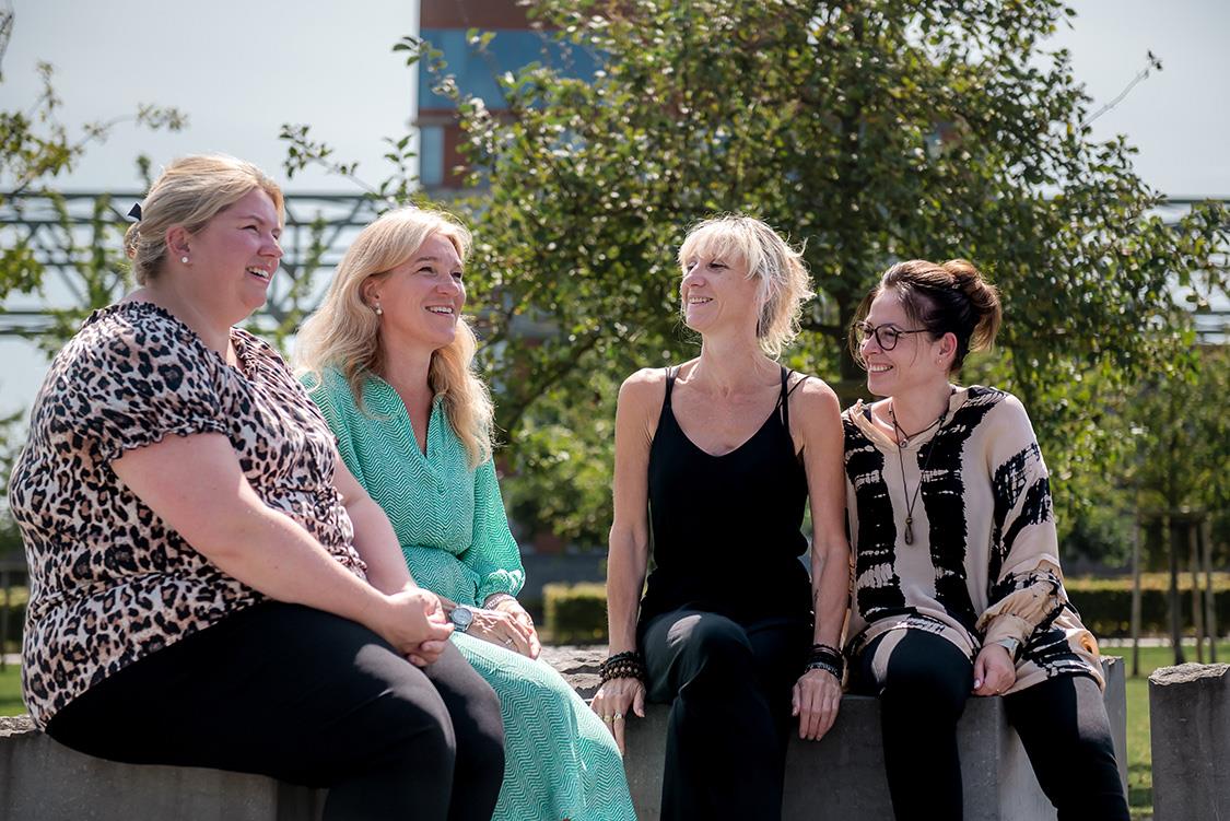 4 women sitting on a bench