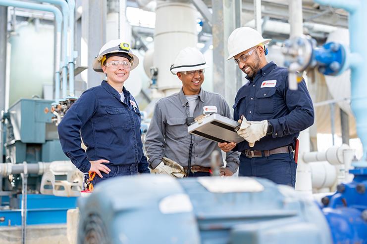 Group of engineers consulting a manual