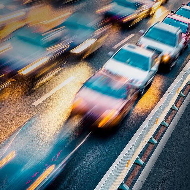 blurred traffic driving on road at night