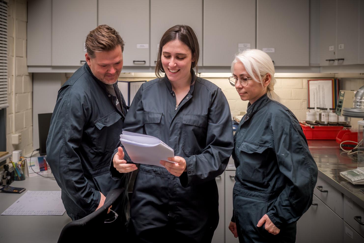 Three employees looking at some paperwork