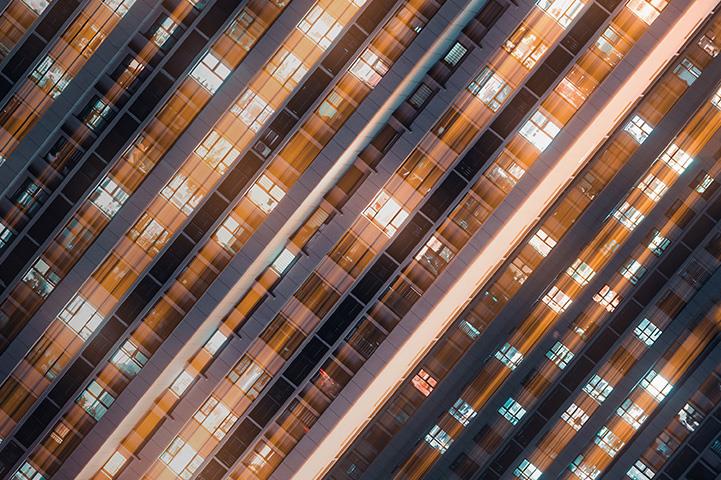 building facade with dozens of lit windows