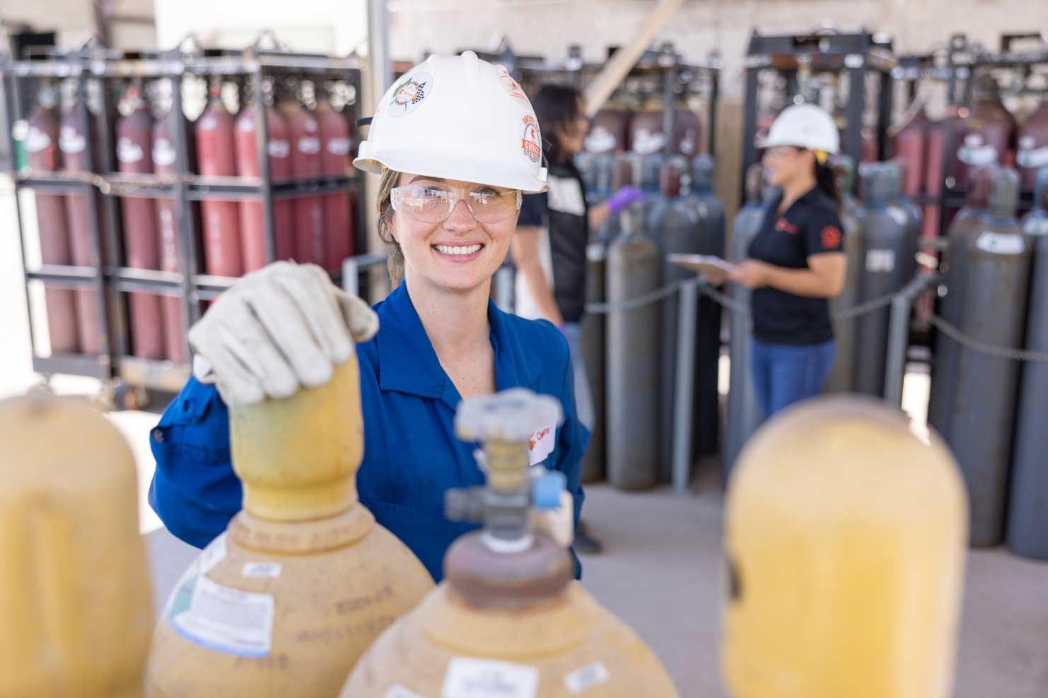 Engineer in hardhat next to air tanks