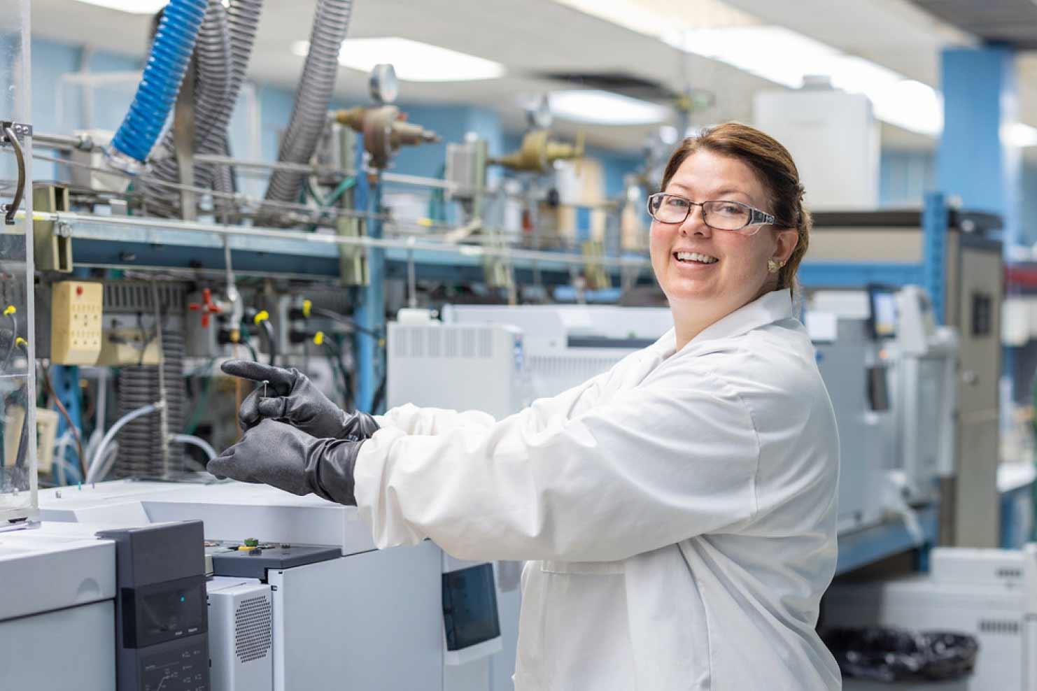 Woman in glasses and scientists coat performing an experiment