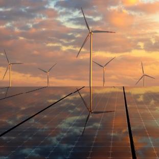 Windmills standing at the end of solar panel arrays