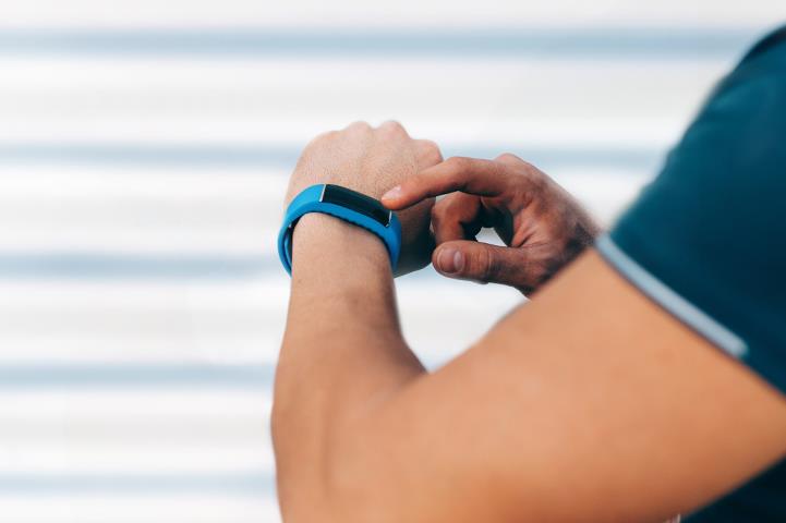 man checking smartwatch with blue band