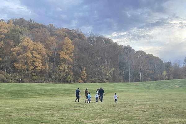Family walking through grass at the bottom of a valley