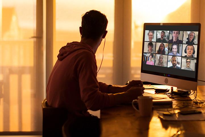An image of a man sitting at a desk looking out the window.