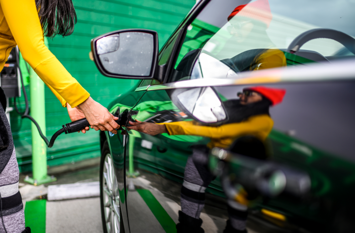 person plugging in electric car