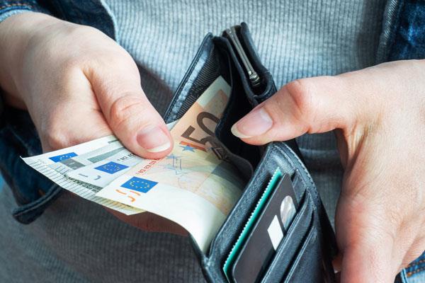person pulling money from a wallet Value