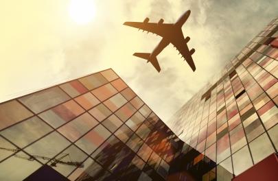 plane flying over buildings