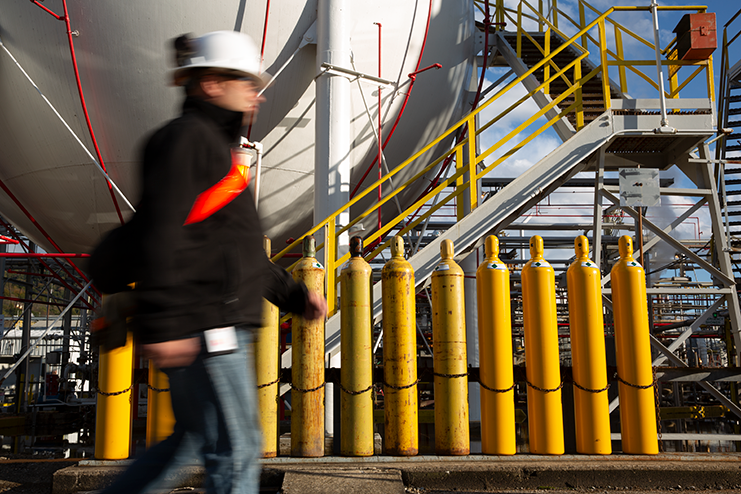 Employee walking past canisters at facility