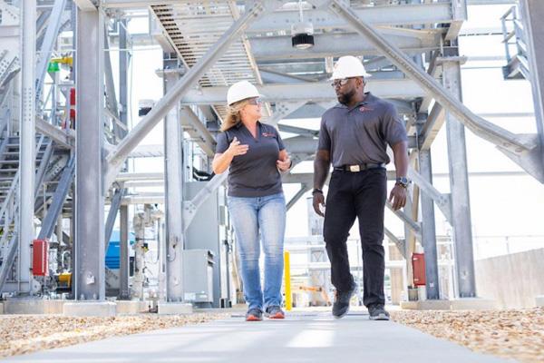 two employees walking under scaffolding