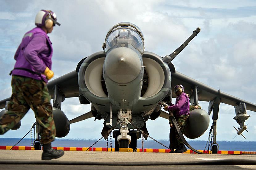 /sitecore/media library/Images/Corporate/Fire Extingushants/PD/one man in bdu walking in front of a harrier jet while another man adds fuel