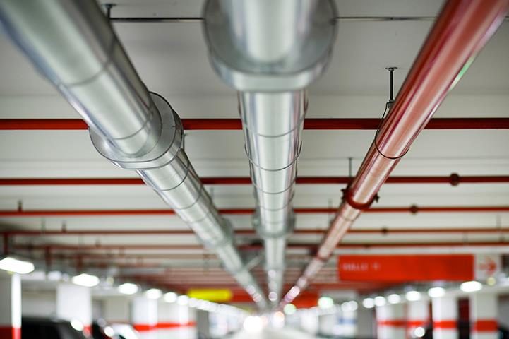 pipes running the length of a parking garage ceiling