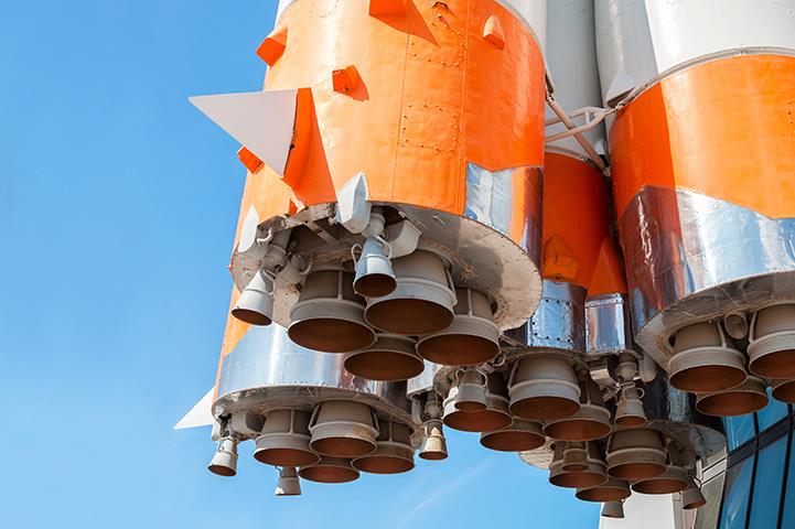 closeup bottom shot of orange and white space rocket engines 