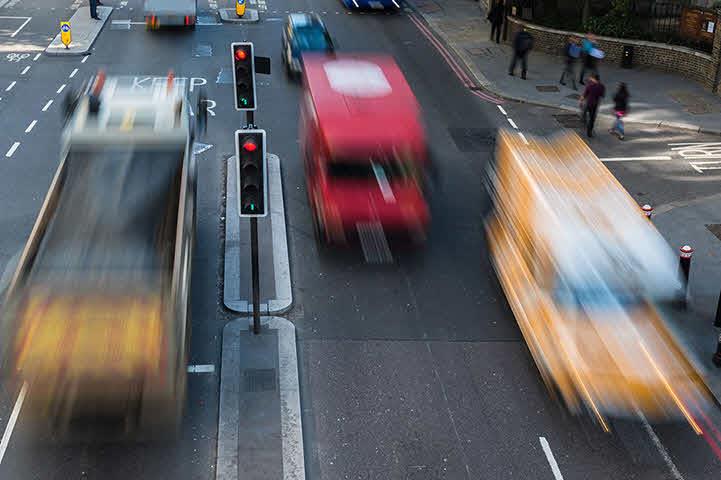An image of blurred traffic traveling down a four lane highway.