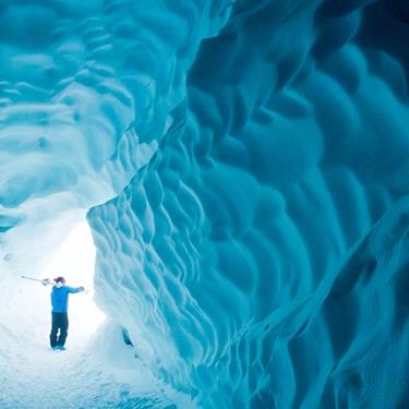 skier at the entrance to an ice cave