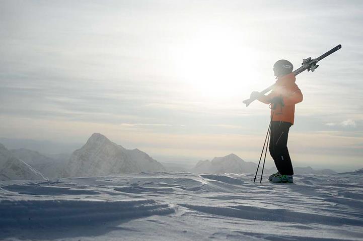 skier standing at the top of a snowy mountain