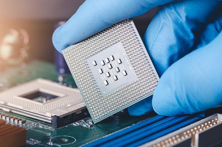 technician laying a cpu on the socket of a computer motherboard